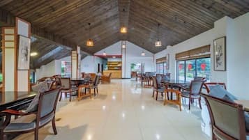 Un vestíbulo espacioso con vigas de madera en el techo, muebles modernos y obras de arte en las paredes.