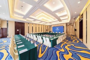 A conference room with a long table, chairs, and a podium. - Chengdu Star Flower Garden Hotel (University Games Sports Center) (Chengdu)