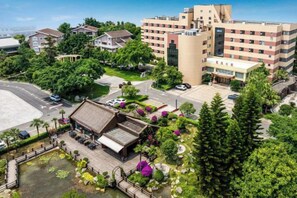 A hotel with multiple floors, a courtyard with a fountain, and surrounding greenery. - Chengdu Star Flower Garden Hotel (University Games Sports Center) (Chengdu)
