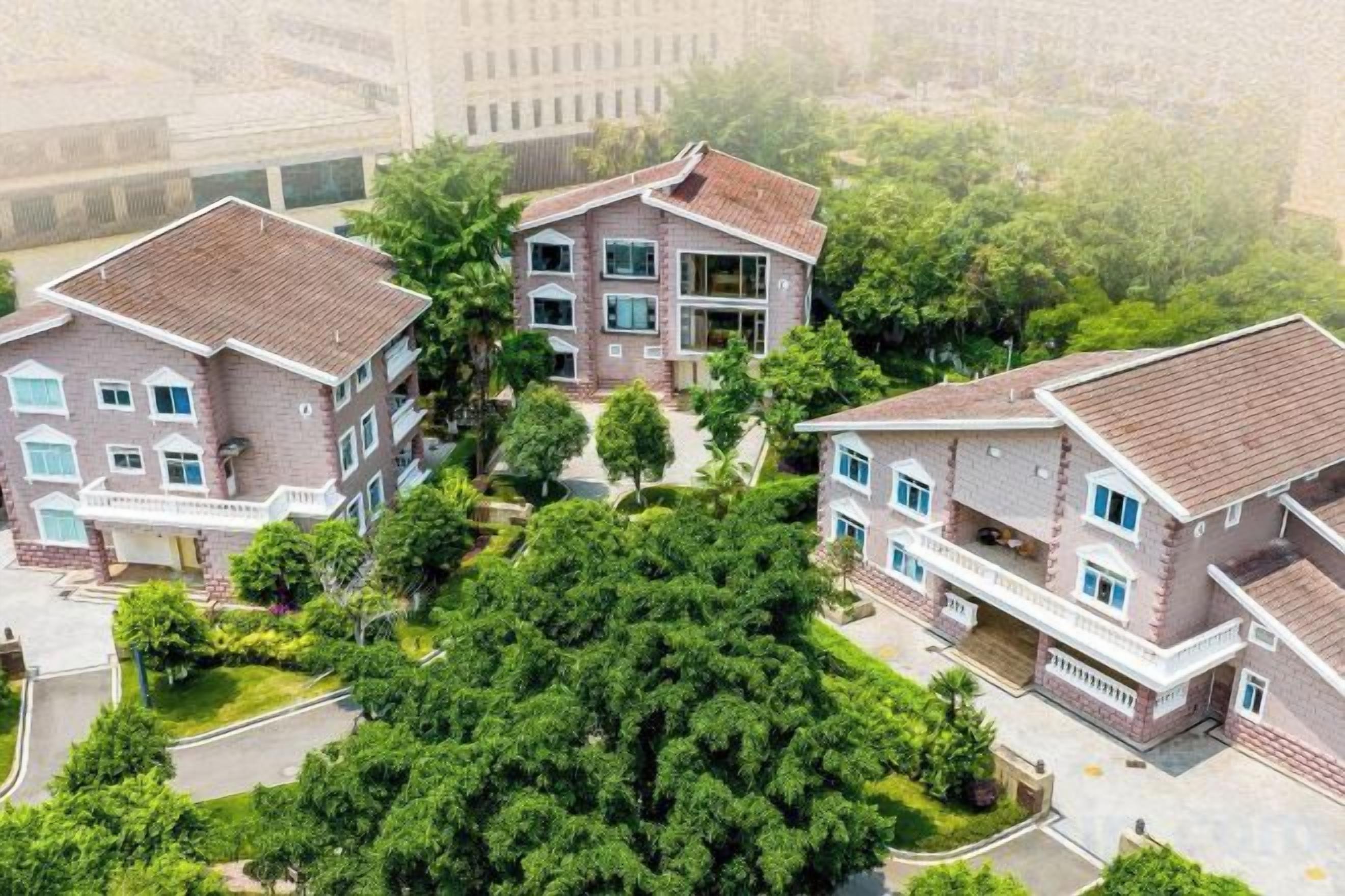Un complejo residencial con varias edificaciones de dos pisos, cada una con balcón y entrada para vehículos.