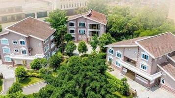 Un complejo residencial con varias edificaciones de dos pisos, cada una con balcón y entrada para vehículos.