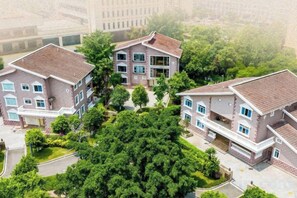 Un complejo residencial con varias edificaciones de dos pisos, cada una con balcón y entrada para vehículos.
