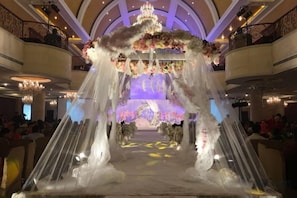 An indoor venue with a central aisle leading to a stage, surrounded by balconies and chandeliers. - Chengdu Star Flower Garden Hotel (University Games Sports Center) (Chengdu)