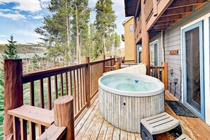 A wooden deck with a hot tub, outdoor seating, and a view of trees and hills. - 3 Bedroom Plus Loft Condo Near Snowflake Lift at Elk Ridge Townhomes (Breckenridge)