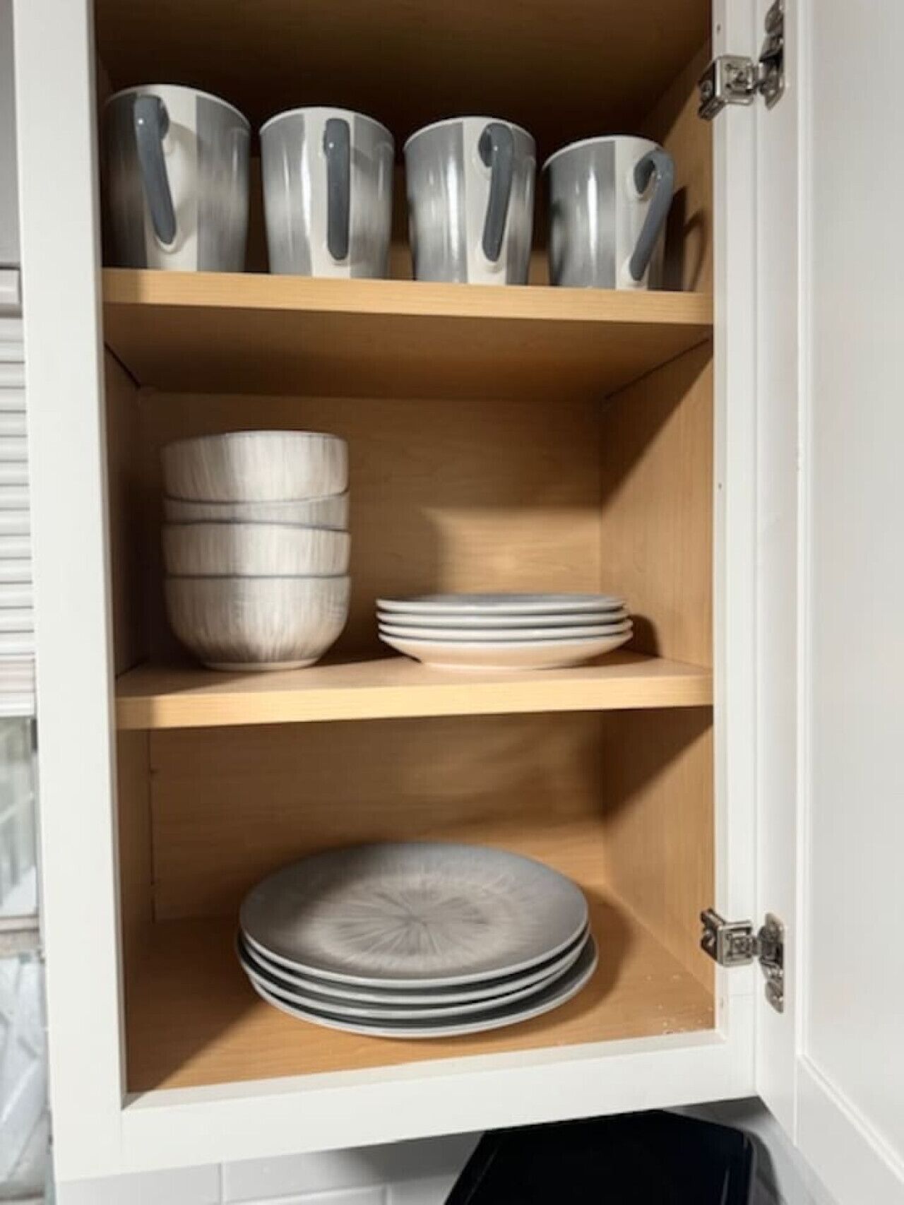 Un mueble con cuatro estantes, cada uno con diferentes utensilios de cocina.