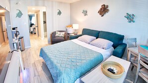 Un dormitorio con cama, escritorio, silla, lámpara y decoración en la pared.