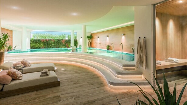 Een moderne spa-ruimte met een gebogen zwembad, zitplaatsen en een houten wand met verlichting.