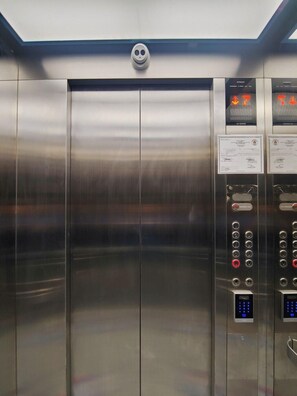 A modern elevator with stainless steel doors, a digital display, and a no-smoking sign. - Reddoorz Plus @ Kaizen Suites Taft Avenue (Manila)