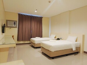 A hotel room with two beds, a desk, and a window with curtains. - Reddoorz Plus @ Kaizen Suites Taft Avenue (Manila)