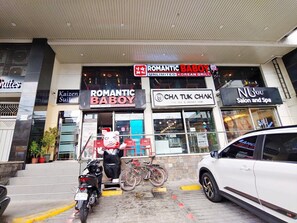 Un immeuble abritant plusieurs commerces, notamment « Romantic Baby Boy » et « Cha Tuk Chak ».