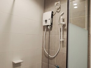 A shower area with a handheld showerhead and a wall-mounted control unit. - Reddoorz Plus @ Kaizen Suites Taft Avenue (Manila)