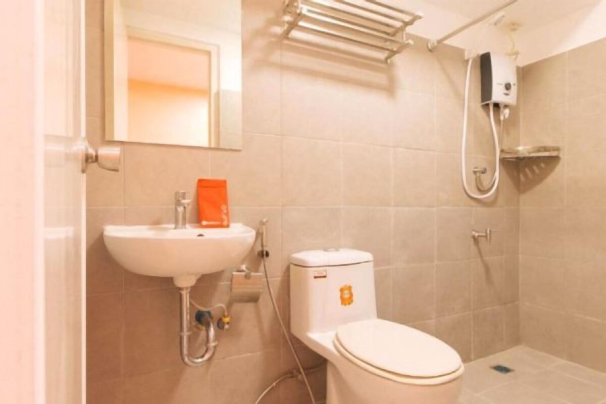 Un bagno con lavandino, water e doccia, tutti in bianco.