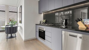 Una cocina moderna con armarios grises, encimera negra y lavavajillas Bosch.