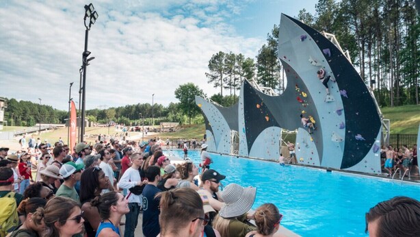 A crowded outdoor swimming pool with a rock climbing wall in the background. - 2xKing-Beds, Birkdale-Plaza-Vista, Shop-Eat-Play (Huntersville)