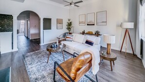 A modern living room with a sofa, leather chair, coffee table, and floor lamp. - 2xKing-Beds, Birkdale-Plaza-Vista, Shop-Eat-Play (Huntersville)