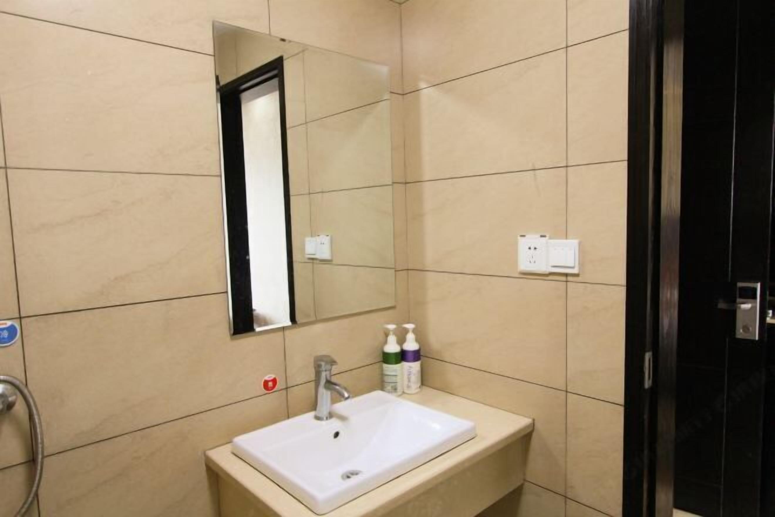A bathroom with a white sink, a mirror, and a towel rack.