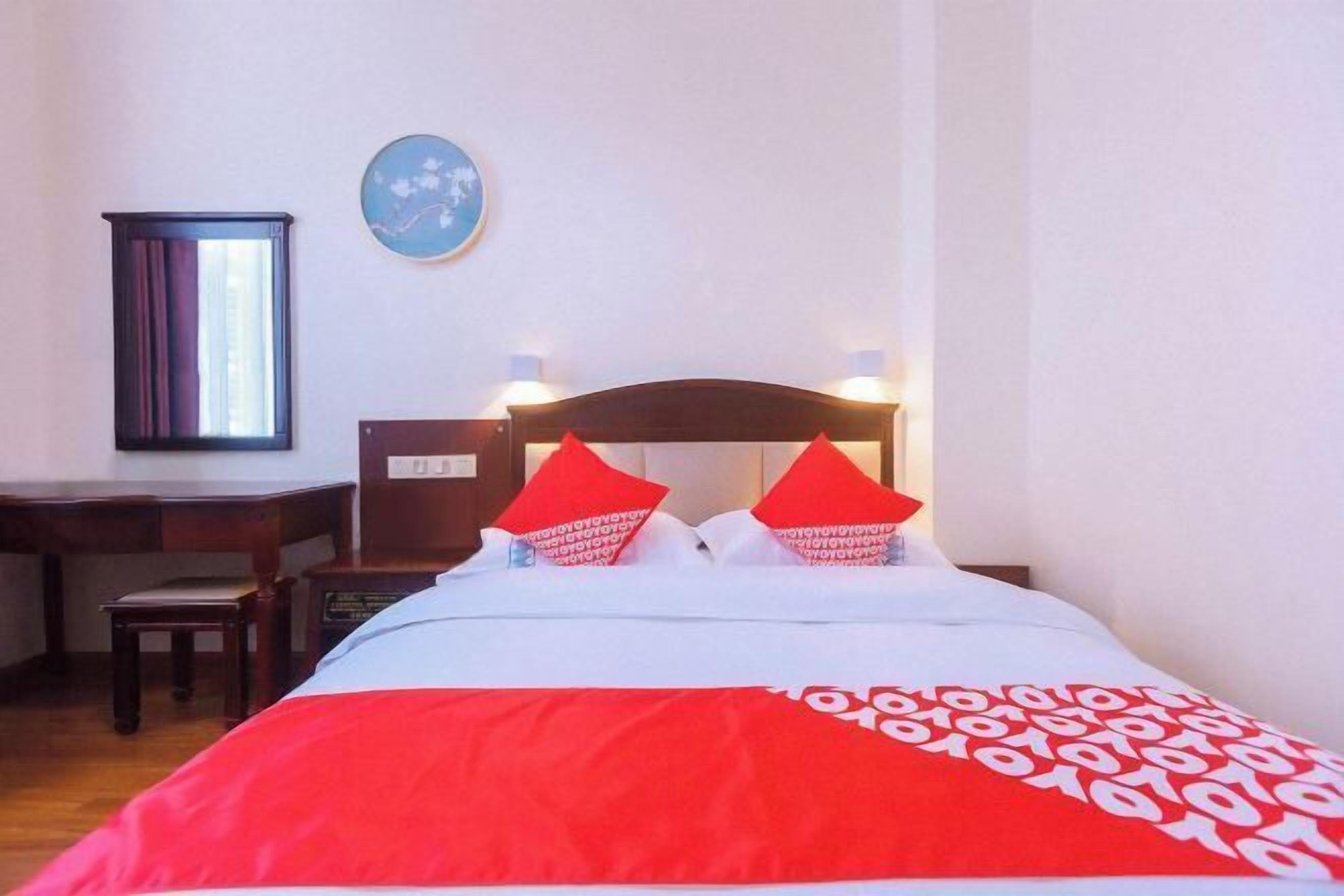 A hotel room with a bed, a desk, and a chair.