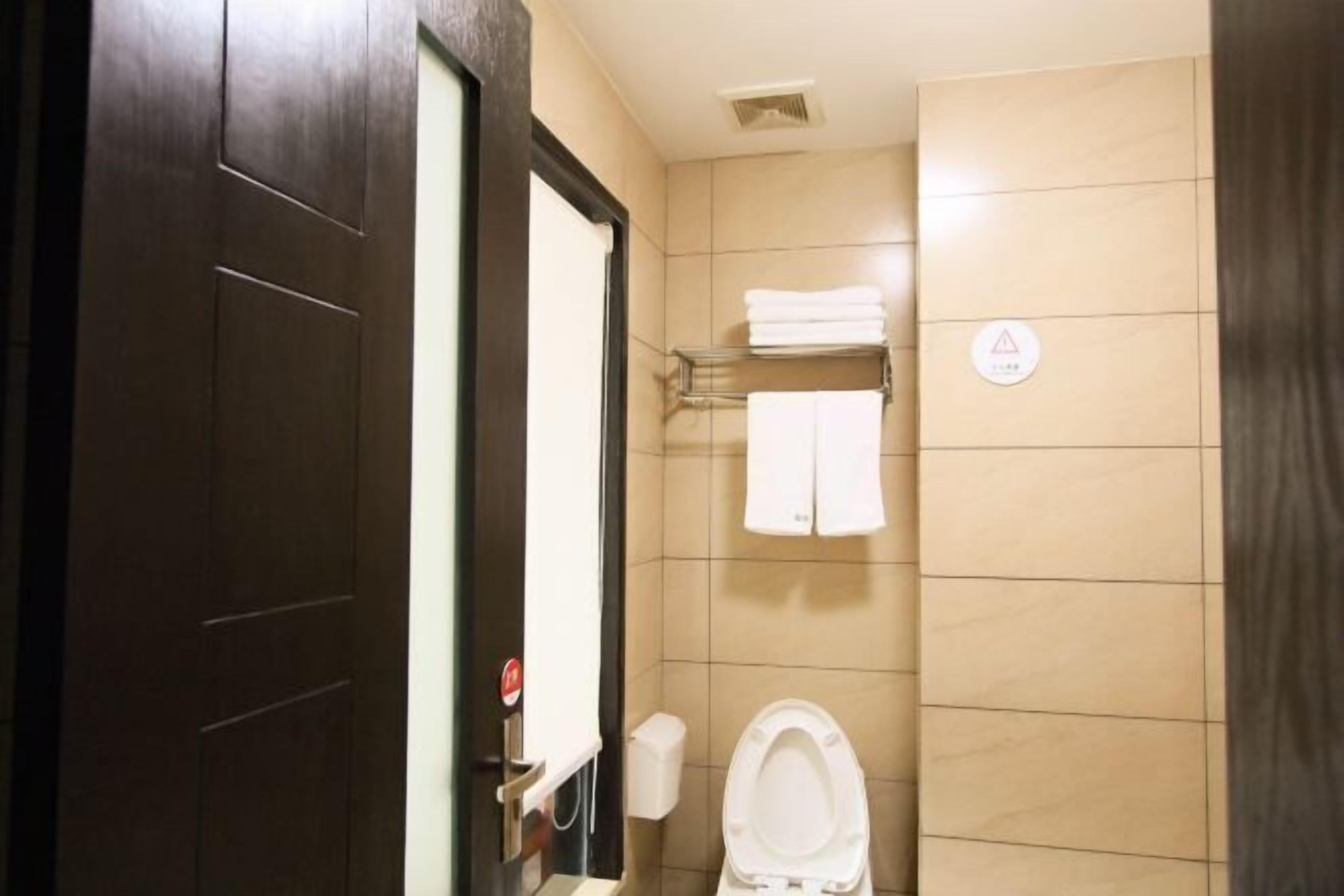 A bathroom with a toilet, a towel rack, and a hand dryer.