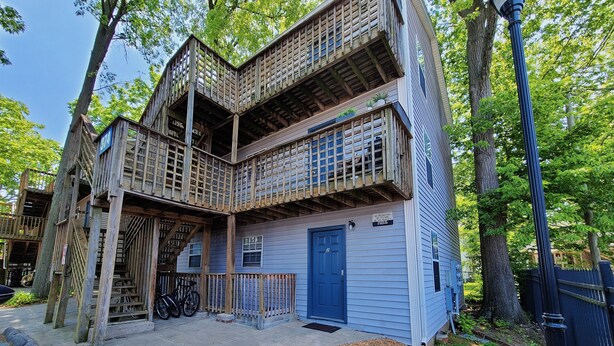 A two-story wooden house with a blue door, surrounded by trees. - Safe & Secure 2br near UKPD in Lex - Rest easy, walk 2 UK (Lexington)