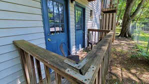 A wooden deck with a blue door and a chair, surrounded by trees. - Safe & Secure 2br near UKPD in Lex - Rest easy, walk 2 UK (Lexington)