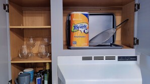 A kitchen cabinet with a dish rack, a can of 'Member's Mark' towels, and various kitchen items. - Safe & Secure 2br near UKPD in Lex - Rest easy, walk 2 UK (Lexington)