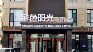 The exterior of the Golden Sunshine Business Hotel with a prominent sign and large windows.