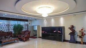 A spacious lobby with a large fish tank, elegant furniture, and a chandelier.