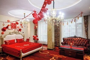 A room with a bed, a sofa, a chandelier, and red decorations. - Changchun Golden Sunshine Business Hotel (Changchun)