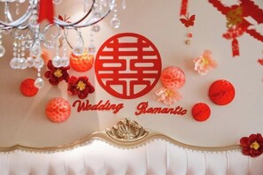A decorative wall with a red emblem and the words "Wedding Romantic" surrounded by floral decorations.