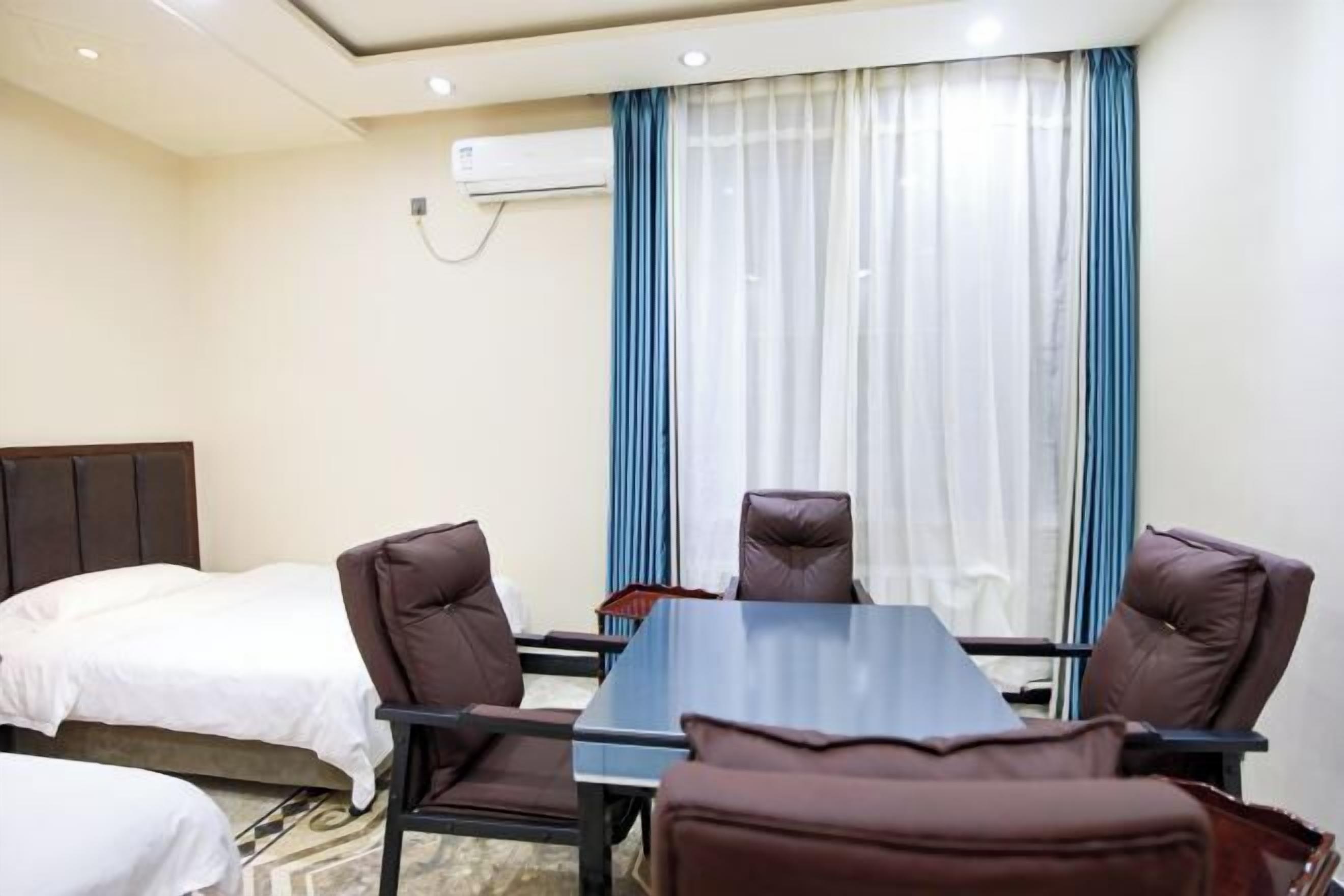Una habitación de hotel con una cama, un escritorio y dos sillas.