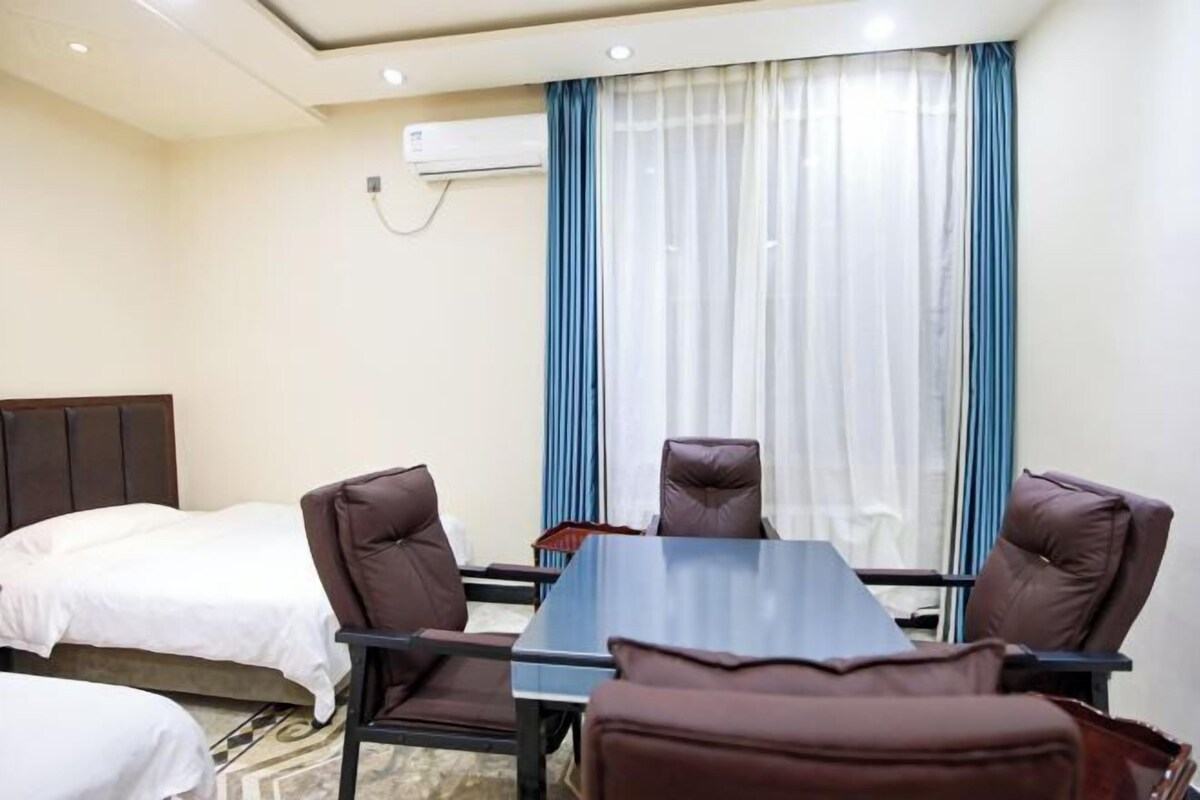 A hotel room with a bed, a desk, and two chairs.