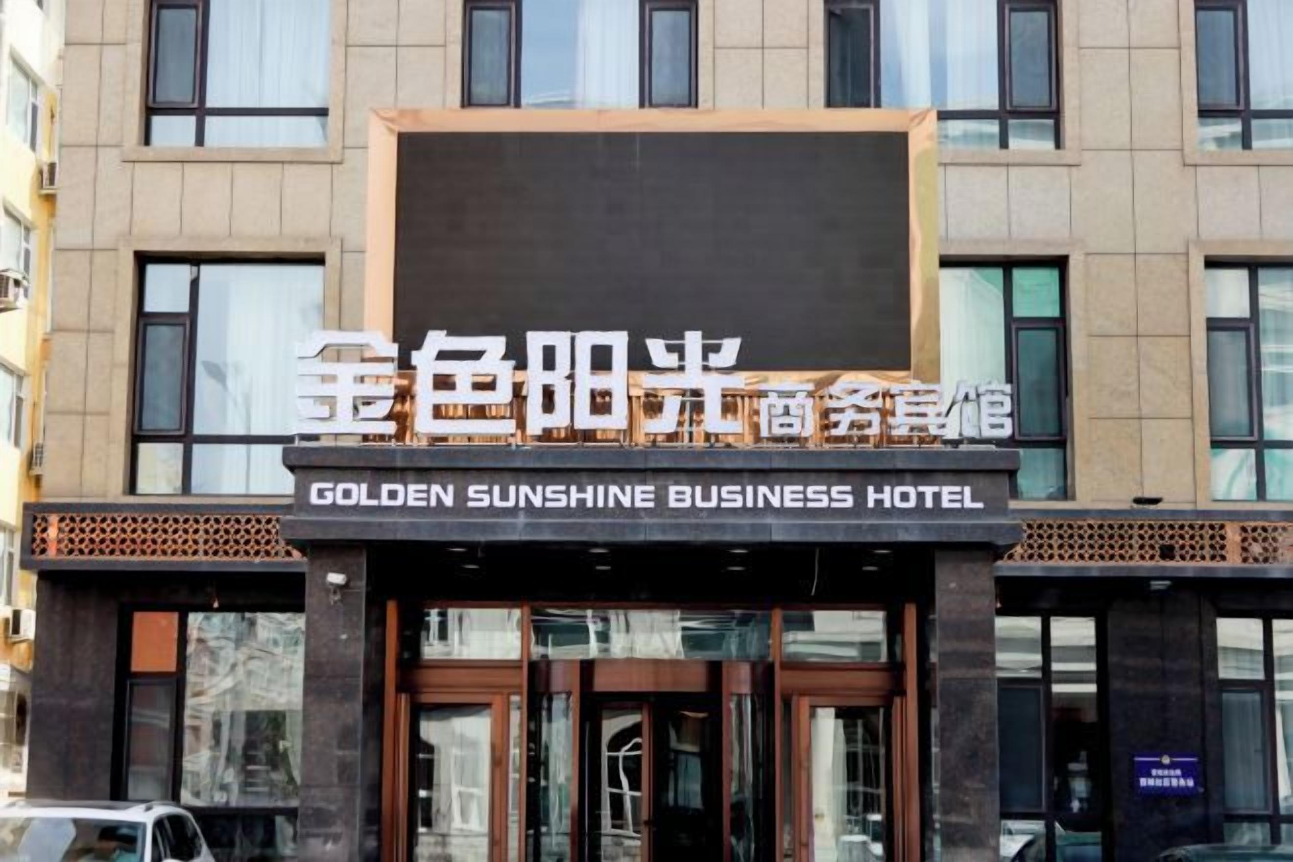 A hotel facade with a sign indicating 'GOLDEN SUNSHINE BUSINESS HOTEL'.