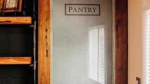 Une porte en bois avec un panneau en verre dépoli portant l’inscription « GARDEMANGER ».