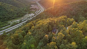 An aerial view of a forested area with a road and a small building. - Hot Tub! Tiny House Retreat in the Woods (Stanton)