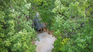 An aerial view of a cabin surrounded by dense forest. - Hot Tub! Tiny House Retreat in the Woods (Stanton)