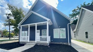 A two-story house with a front porch, a garage, and a driveway. - New Home, Walk to Clinic, Private Patio & Hot Tub! (Cleveland)