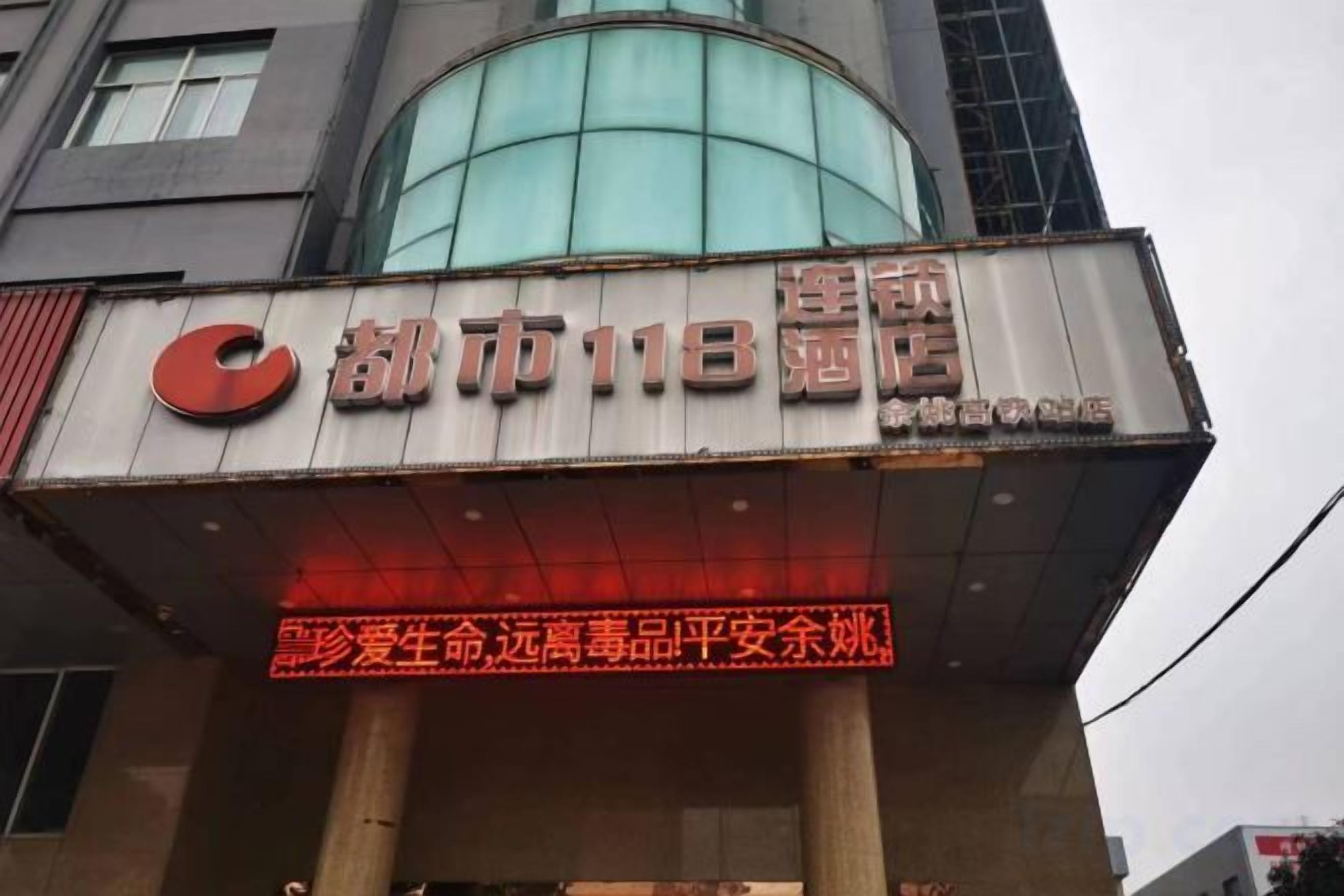 A building with a sign that reads 'City 118' and a neon sign below it.
