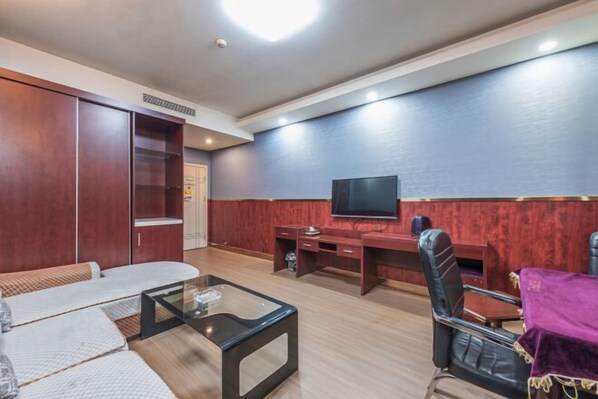 A modern living room with a sofa, a glass coffee table, a TV, and a desk with a chair. - Dushi 118 Chain Hotel (Ningbo Yuyao High‑speed Railway North Station Branch) (Yuyao)