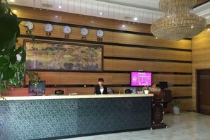 A reception desk with a digital screen, clocks, and a large painting on the wall. - Dushi 118 Chain Hotel (Ningbo Yuyao High‑speed Railway North Station Branch) (Yuyao)