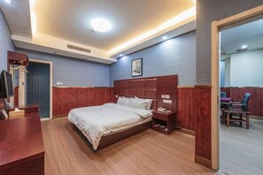 A hotel room with a large bed, wooden headboard, bedside table, and a small desk with a chair. - Dushi 118 Chain Hotel (Ningbo Yuyao High‑speed Railway North Station Branch) (Yuyao)