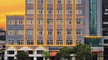 Un hotel de varios pisos con una fachada plana y una cuadrícula de ventanas.