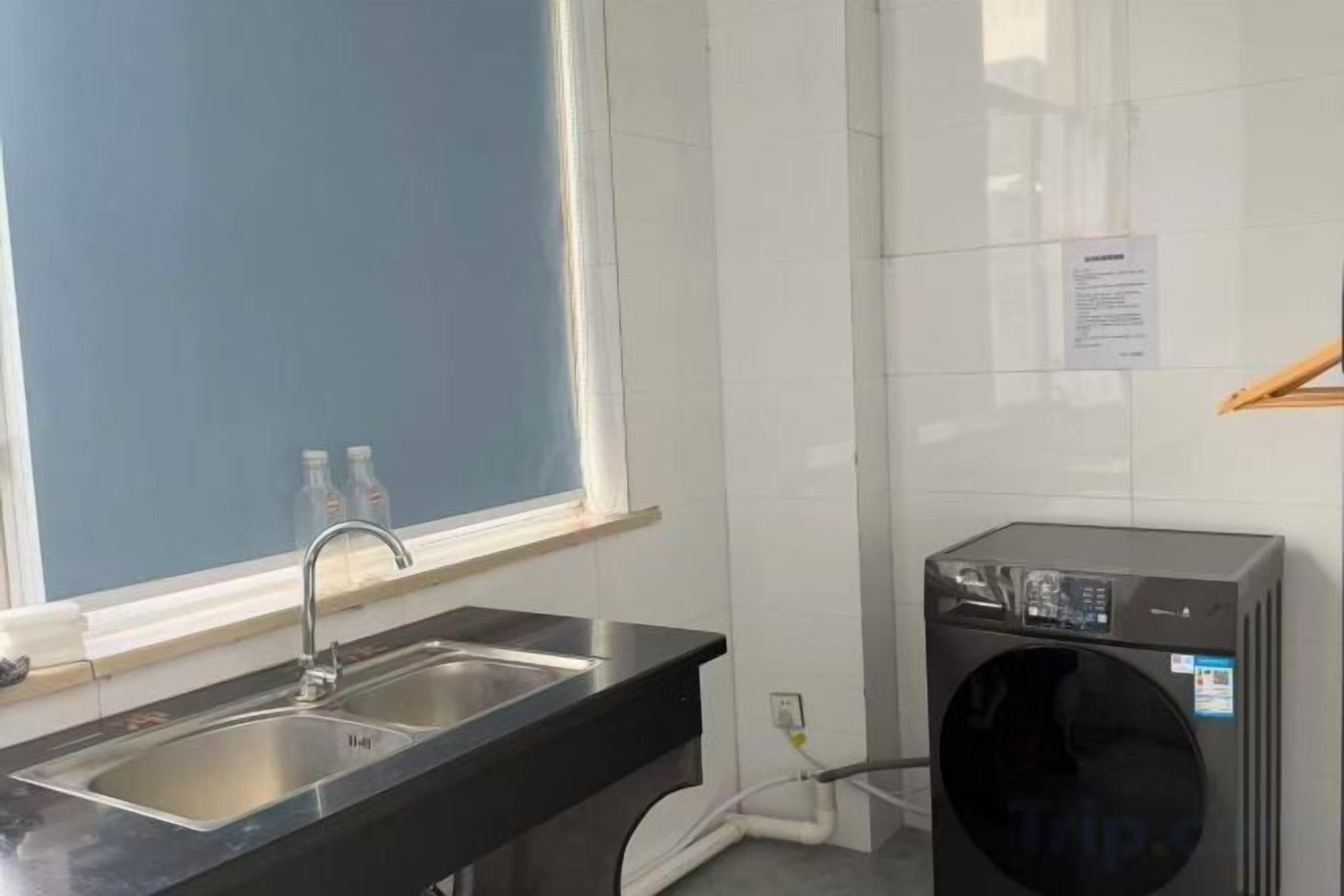 Una cocina con un lavabo, una ventana y una lavadora.