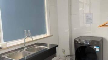 Una cocina con un lavabo, una ventana y una lavadora.