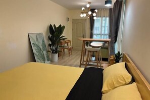 Ein Hotelzimmer mit einem Bett, einem Schreibtisch, Stühlen und Blumentöpfen.