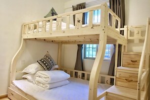 Un letto a castello con struttura in legno, un cuscino e un piccolo cassetto.