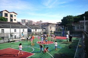 Un terrain de basket en plein air, entouré d’immeubles.