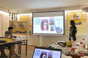 Une salle de conférence équipée d’un écran de présentation, d’un ordinateur portable et d’un projecteur.