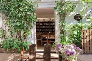 Ein Eingangsbereich mit einem Holztor, einem Holztisch und einem Bücherregal im Hintergrund.