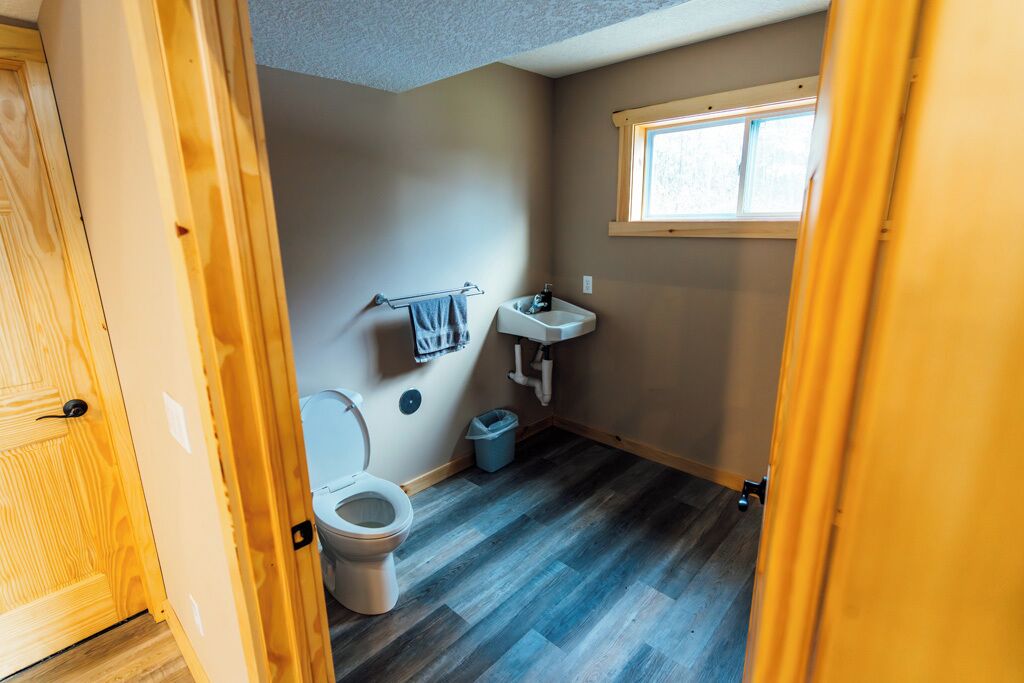 Une petite salle de bain comprenant des toilettes, un lavabo et une fenêtre.