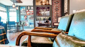Una sala de estar con sofá, un comedor con mesa y sillas, y una pared decorada con cuadros.